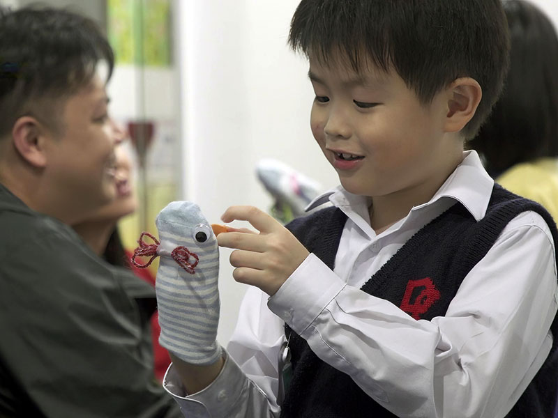 "Young child playing with a puppet attending drama stars course at English for Asia Learning Centre"